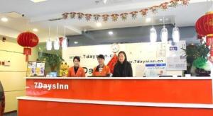 a group of people standing at the counter of a restaurant at 7 Days Inn Changzhou North Station in Changzhou