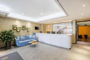 a lobby with a blue couch and a reception desk at GreenTree Inn Tianjin JinNan ShuangLin Metro Station Express Hotel in Tianjin