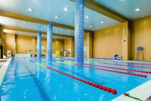 a large swimming pool in a large room at GreenTree Inn Tianjin JinNan ShuangLin Metro Station Express Hotel in Tianjin