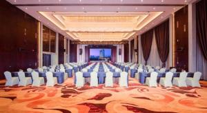 Un gran salón de banquetes con sillas blancas y una gran alfombra. en New Century Grand Hotel Xi'an Xizang Building, en Xi'an 251 fotos más