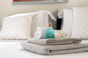 - une pile de serviettes et une bouteille de savon sur le lit dans l'établissement Casa Bianchina, à Albiolo