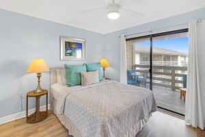 a bedroom with a bed and a balcony at 33C Lighthouse Point in Tybee Island +24 photos