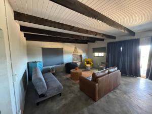 - un salon avec un canapé et des chaises dans l'établissement Keurkloof Farm villas off R62, à Plathuis