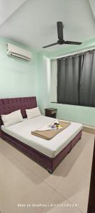 Bett in einem Schlafzimmer mit Deckenventilator in der Unterkunft Hotel Comfort Vesu in Surat