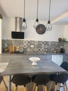 Una cocina con una mesa con sillas y un reloj en la pared. en Maison BRIALI avec Jacuzzi espace détente, en Aubignan 40 fotos más
