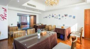 a dining room with a table and chairs and a chandelier at Lavande Hotel Changsha High-Speed Railway Station Shumuling Metro Station in Changsha