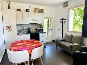 a kitchen with a table and a couch in a room at La maison des Huskys in Sasso di Bordighera