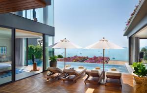 een huis met een zwembad en een patio met parasols bij V Villas Phuket - MGallery Collection in Panwa Beach
