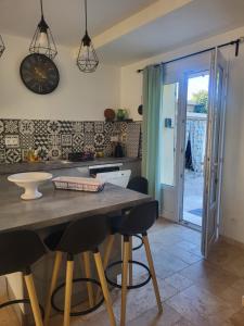 Una cocina con una mesa y sillas en una habitación. en Maison BRIALI avec Jacuzzi espace détente, en Aubignan