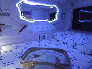 a small room with a bed and a tv at Hotel Galaxy Pod 本川越店 in Kawagoe