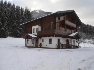 a large wooden building with snow on the ground at Beautiful apartment in Mittersill with balcony in Mittersill