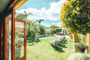 a yard with chairs and a swimming pool at Villa Chad Luxury Guesthouse in Kleinmond