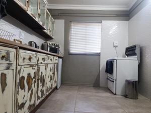 a kitchen with a stove and a refrigerator at La Mouna 4 in Bultfontein in Bultfontein