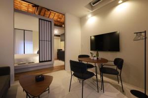 a living room with a table and chairs and a bed at Miharaya in Onomichi