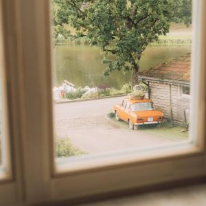 an orange car is parked next to a building at Apartaments Nr 33 Viesu Nr 2 in Talsi