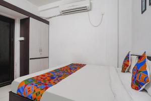 ein Schlafzimmer mit einem Bett mit einer bunten Decke darauf in der Unterkunft FabHotel The Vinayak in Bhopal