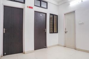 3 Türen in einem Zimmer mit weißen Wänden in der Unterkunft FabHotel The Vinayak in Bhopal + 16 Fotos
