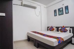 ein Schlafzimmer mit einem Bett in einem Zimmer in der Unterkunft FabHotel The Vinayak in Bhopal