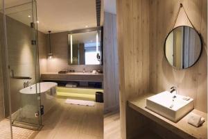 a bathroom with a sink and a mirror at Discovery Hotel in Magong