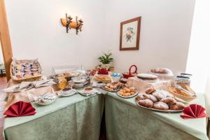 dos mesas con diferentes tipos de pan y repostería en Hotel Sorapiss, en Misurina