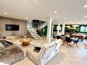 a living room with two couches and a dining room at villa NOESIS in Grosseto-Prugna