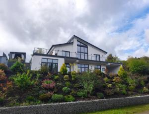 een wit huis met een tuin ervoor bij Modernes Apartment in ruhiger Lage inklusive Fitnessgeräte für Ihr Workout zu Hause in Drolshagen