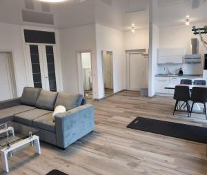 een woonkamer met een bank en een keuken bij Modernes Apartment in ruhiger Lage inklusive Fitnessgeräte für Ihr Workout zu Hause in Drolshagen