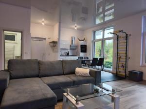 een woonkamer met een bank en een tafel bij Modernes Apartment in ruhiger Lage inklusive Fitnessgeräte für Ihr Workout zu Hause in Drolshagen +13 foto's