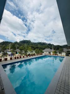a large swimming pool with blue water in a building at Oisca Furusato Village By Le Miste in Vayittiri