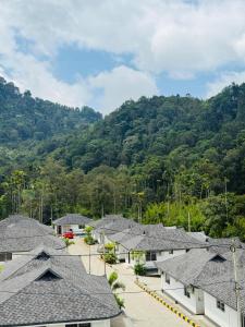 a row of houses with mountains in the background at Oisca Furusato Village By Le Miste in Vayittiri