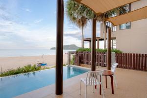 Un patio con mesa y sillas y la playa. en YOD Sam Roi Yot, en Baanphakrimlay 