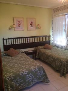 um quarto com 2 camas e uma janela em Hostal Monica em Cilleruelo de Bezana