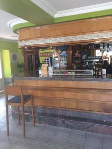 um bar com um balcão de madeira e uma cadeira em Hostal Monica em Cilleruelo de Bezana