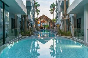 ein Swimmingpool mitten in einem Gebäude in der Unterkunft Palmyrah Surin Apartments, Phuket, by the Sea in Ban Lum Fuang
