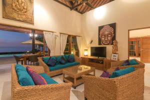 a living room with a couch and chairs and a television at Villa Cerah in Pengastulan