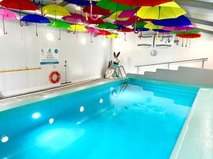 a swimming pool with umbrellas hanging above it at Netherdale House & The Coach House in Turriff