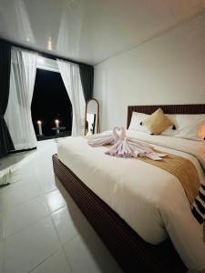 a bedroom with a bed with a dress on it at Batur Jemsokin Logement in Bangli