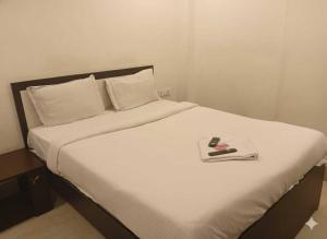 ChanakにあるHotel O Swami Vivekananda University Kolkataのナイフと皿が置かれた白いベッド