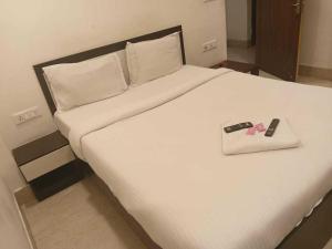 ChanakにあるHotel O Swami Vivekananda University Kolkataの白いベッド(リモコン2台付)