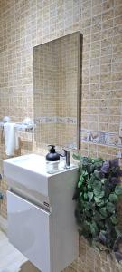 Un baño con un lavabo blanco y un espejo. en iris appart vue dégagée, bon emplacement, en Sale