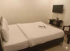 ChanakにあるHotel O Swami Vivekananda University Kolkataのベッドルーム1室(ベッド1台、リモコン付)