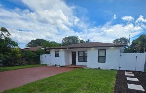 a small white house with a white fence at Delray Beach Sunshine - 5 minutes from beach! in Delray Beach