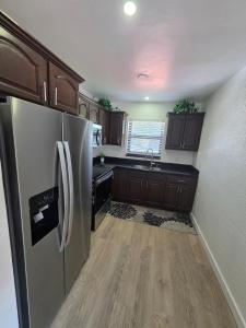 a kitchen with a stainless steel refrigerator and wooden cabinets at Delray Beach Sunshine - 5 minutes from beach! in Delray Beach