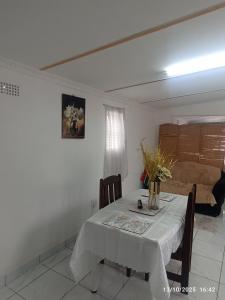 een eetkamer met een tafel en een bank bij Chez Matli in Tiervlei