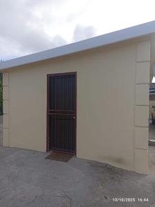 een wit gebouw met een grote deur erop bij Chez Matli in Tiervlei