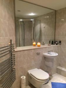 a bathroom with a toilet and a sink and a mirror at A double room in a great location in Southampton