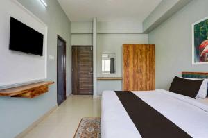 a bedroom with a large bed and a flat screen tv at Collection O Kesar Crossway Jaipur Formerly Laxmi Palace in Jaipur