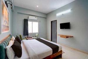 a bedroom with a large bed and a television at Collection O Kesar Crossway Jaipur Formerly Laxmi Palace in Jaipur