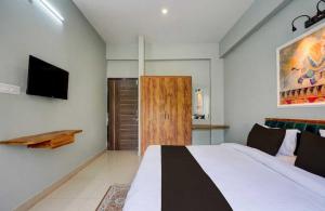 a bedroom with a bed and a flat screen tv at Collection O Kesar Crossway Jaipur Formerly Laxmi Palace in Jaipur