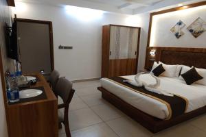 a bedroom with a bed and a desk and a sink at Townhouse Cochin Airport Formerly Skyluxe in Nedumbassery